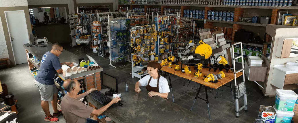 Foto da loja, mostrando as prateleiras com materiais e funcionários trabalhando